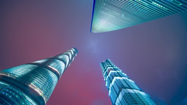 Clouds moving close to three towers a look up timelapse clip at night in Shanghai
