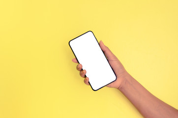 Human hand holding smartphone with white screen background.