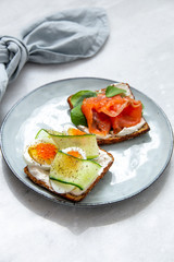 Smorrebrod - danish open sandwich with fish, vegetables, cheese on marble background. Top view with copy space