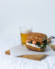 beer and sandwich with smoked salmon, red caviar, cream cheese, and kale cabbage