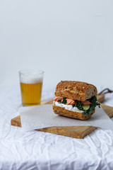 beer and sandwich with smoked salmon, red caviar, cream cheese, and kale cabbage