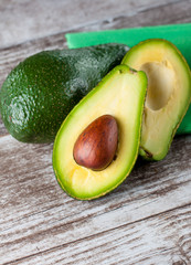 Close-up of an avocado and avocado oil on wooden table. Healthy food concept.