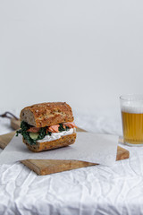 beer and sandwich with smoked salmon, red caviar, cream cheese, and kale cabbage
