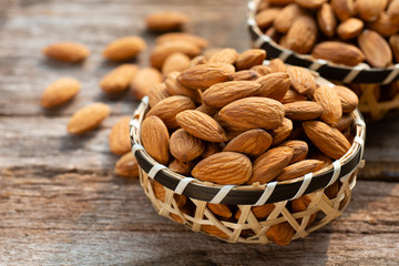 Almonds nuts in wooden bowl on wood table.