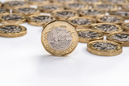 UK money, picture shows pound coin standing on edge with background of coins 