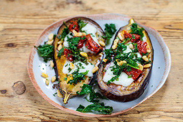 Roast aubergine with goat cheese, sun dried tomatoes, crispy kale and pine nuts