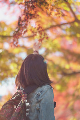 woman with leaves in autumn park