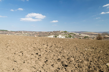 Plowed field in spring time with blue sky