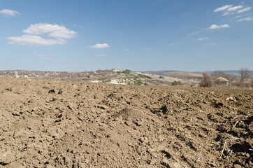 Plowed field in spring time with blue sky