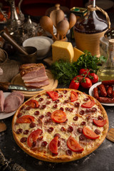 Pizza with ham and smoked sausages for a restaurant menu.