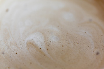 Foam on coffee close-up. Foam in the shape of heart background