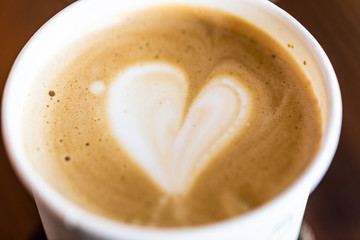 Foam on coffee close-up. Foam in the shape of heart background