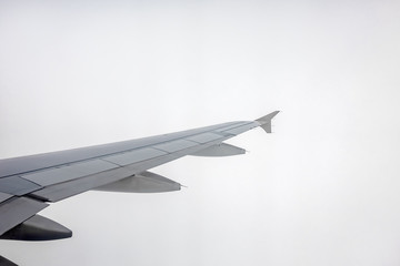 Fototapeta na wymiar Window view of the wing of an airplane