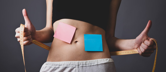 Beautiful and strong woman's abs with metre and notes
