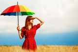 Redhead girl with umbrella at field