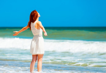 Redhead girl on the beach in spring time.