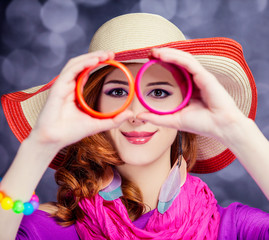 Beautiful red-haired girl in hat at bokeh background
