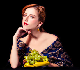 Portrait of beautiful rich women with grapes.