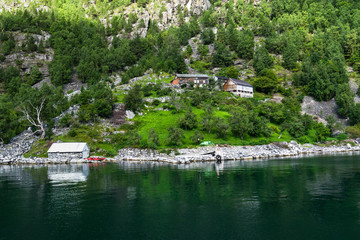 Fototapeta na wymiar Farms along the slopes of the Geirangerfjord viewed from a cruise ship, Sunnmore, More og Romsdal, Norway