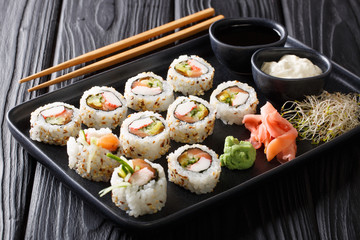 Asian uramaki rolls with salmon and crabs closeup on a plate. horizontal