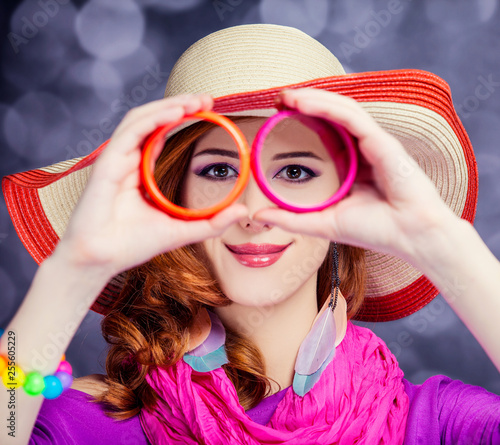 Beautiful red-haired girl in hat at bokeh background
