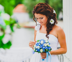 Portrait of young bride with flower bouquet.