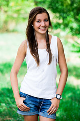Beautiful teen girl in the park with headphones.