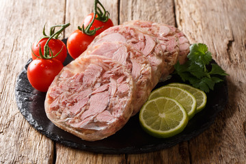 Healthy tasty food head cheese or brawn and fresh tomatoes, lime and cilantro closeup on a slate...