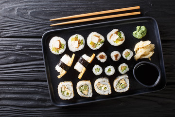 Japanese rolls set with tuna, tofu, eel, avocado, tamago closeup on a plate. Horizontal top view