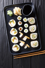 Japanese rolls set with tuna, tofu, eel, avocado, tamago closeup on a plate. Vertical top view