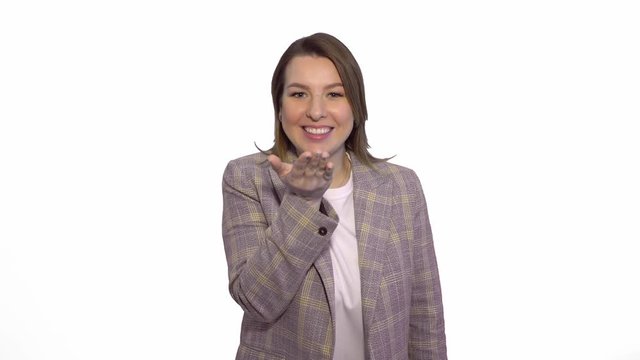 Smiling woman sends air kiss at the camera over white background chromakey