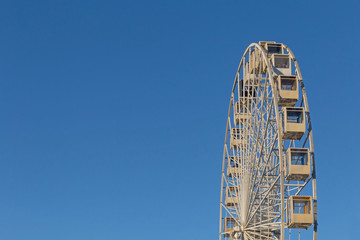 top of ferris wheel against blue sky in Kyiv