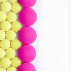 Yellow and pink pills on a white background.
