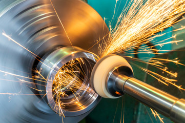 End processing of a metal surface with an abrasive stone on a circular grinding machine, sparks fly...