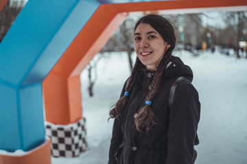 Girl walking in the fresh air in winter. Cheerful and beautiful woman posing on the street, in the city Park. Concept: a walk in the fresh air, the guarantee of health and good mood