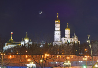 Fototapeta na wymiar View of the illuminated buildings and the cathedrals of the Kremlin at night. Russia, Moscow, March 2019