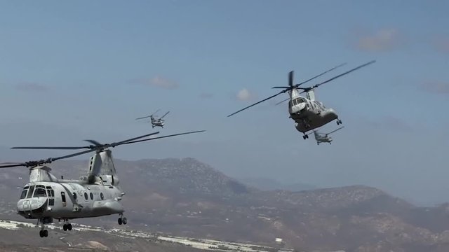 Marines flying double propeller helicopters.