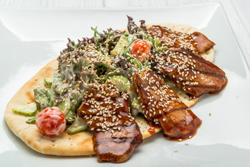 Pita with meat and vegetable salad on the plate