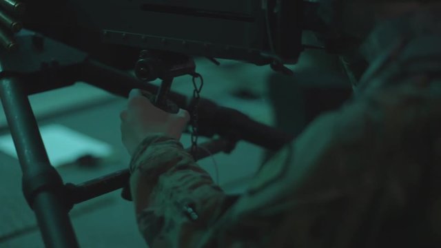 Marine shooting and adjusting a machine gun.