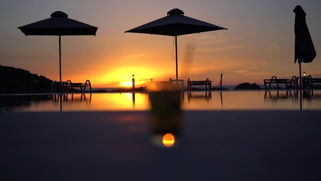 sunset at the pool with coctkail 