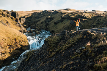woman looking at picturesque waterfall, Iceland. Nordic nature