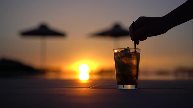 glass of cocktail on sunset by the pool