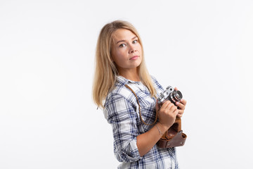 Technologies, photographing and people concept - blonde young woman with retro camera over white...