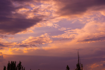 Naklejka premium Krajobraz z dramatycznym światłem - piękny złoty zachód słońca z nasyconym niebem i chmurami.