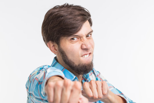 Expression and gesture concept - Portrait of angry man showing his fists on white background