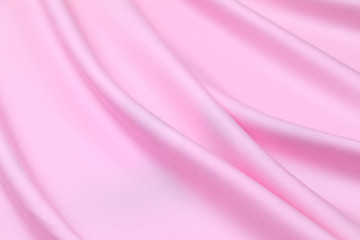 Pink saturated plastic fabric is laid by diagonal soft folds