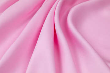 Pink saturated plastic fabric is laid by diagonal soft folds