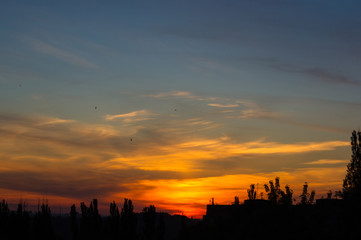 Landscape with dramatic light - beautiful golden sunset with saturated sky and clouds.