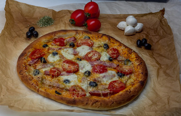 Fragrant pizza on the background of tomatoes and mozzarella
