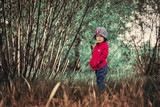A lonely serious child in a magical forest. Sad eyes. Without tears.
